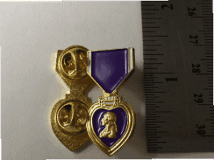 Purple Heart medal with a ruler nearby.