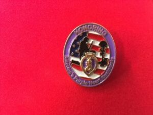 Purple Heart pin on red background.