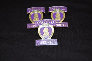 Three purple heart proud supporter pins.