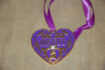 Heart-shaped purple merit medal with ribbon.