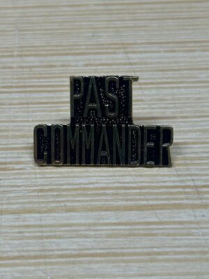 Past Commander pin on striped surface.