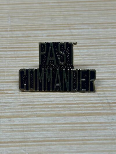 Past Commander pin on striped surface.
