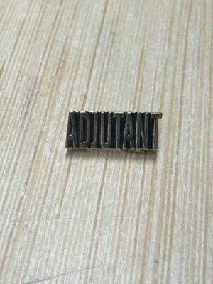 Adjutant pin on wooden surface.