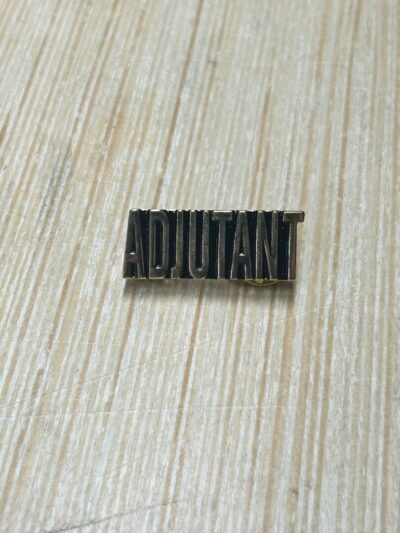 Adjutant pin on wooden surface.
