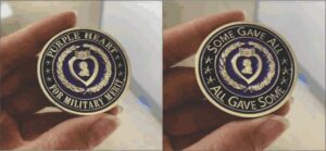 Purple Heart commemorative coin held in hand.