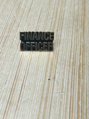 Finance Officer badge on wooden surface.