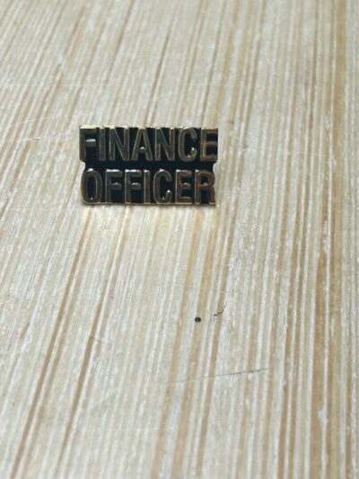Finance Officer badge on wooden surface.