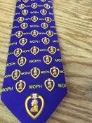 Purple tie with repeating emblem pattern.