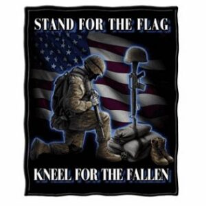 Soldier kneeling before memorial, American flag background.