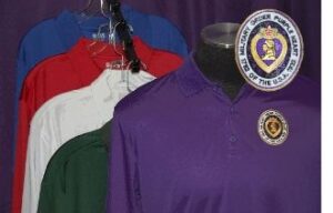 Purple polo shirt with embroidered military emblem.