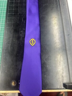 Purple necktie with a yellow emblem.
